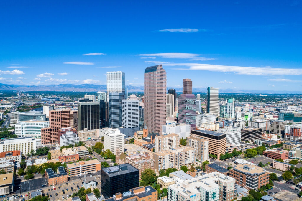 Denver, Colorado skyline, with the Wells Fargo Center and Rocky Mountains in the background