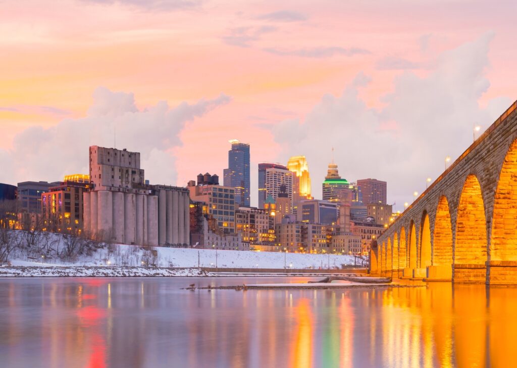 Snow-dusted Minneapolis skyline at dusk with the Mississippi River