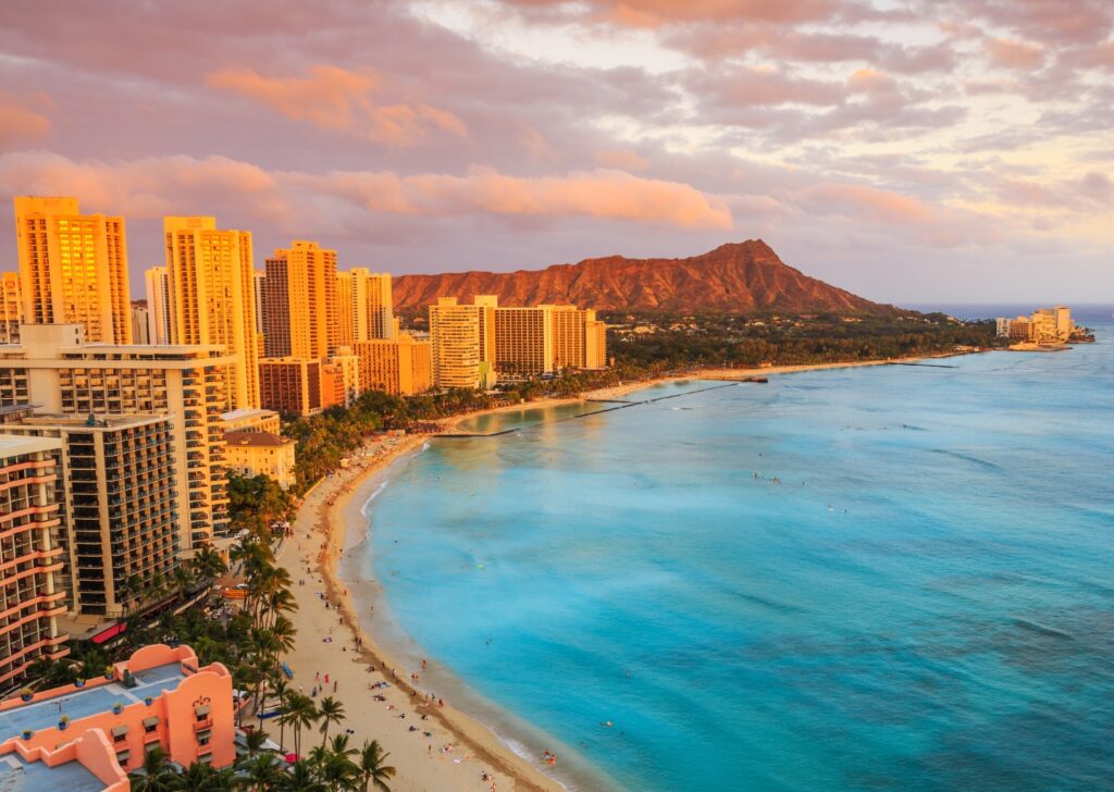 Palm-lined coastline of Oahu with volcanic mountains in the background