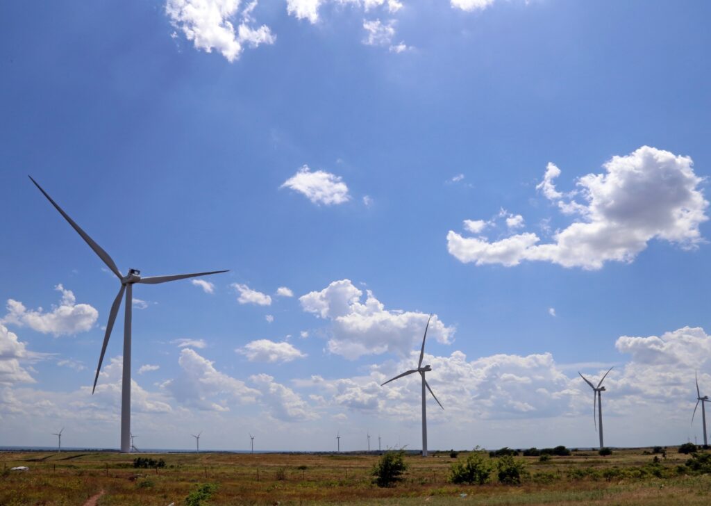 Golden fields and windmills under a wide Oklahoma sky