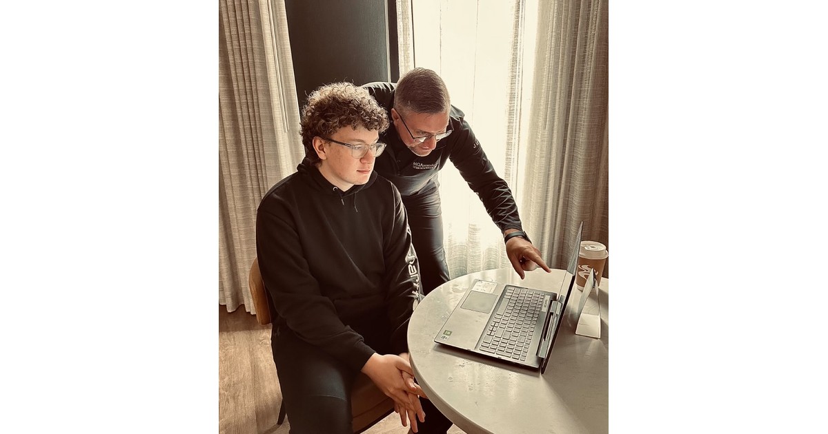 Jayson Lowe leans over a laptop with his teenage son Jaxson Lowe, reviewing Jaxson's dividend investments