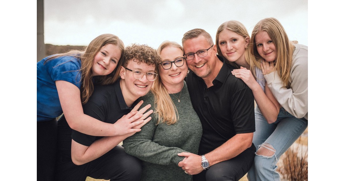 Family portrait of Jayson Lowe, his wife Rebecca Lowe, their son and their daughters smiling together outdoors